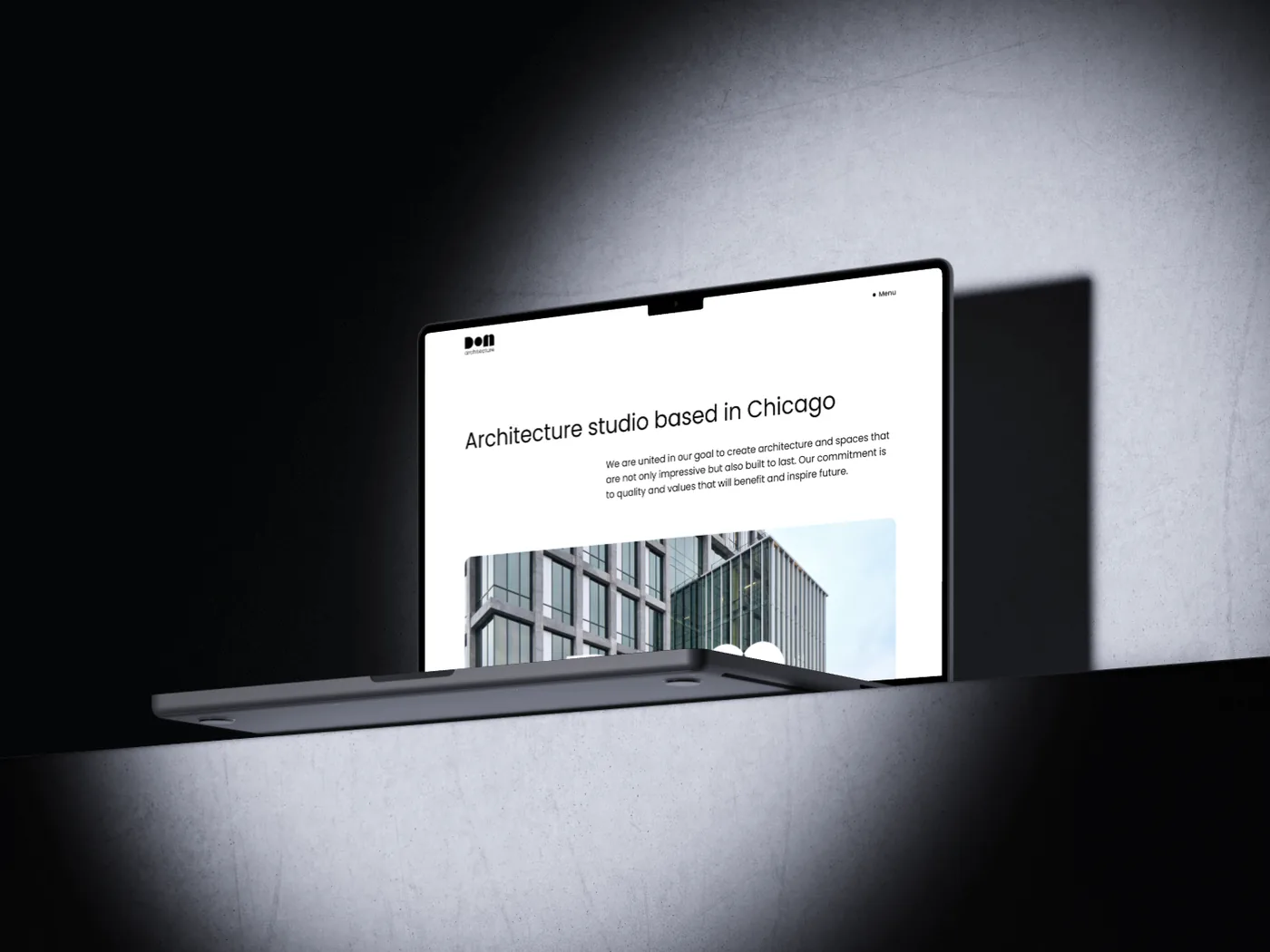 The DOM website open on a laptop on a concrete ledge in hard light