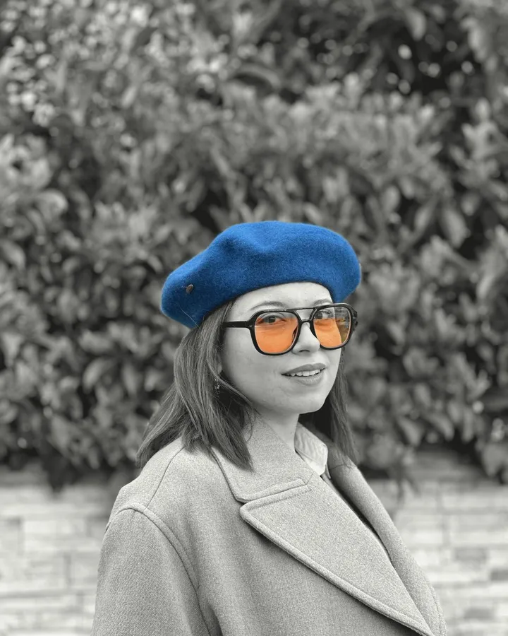 Banu Kahvecioğlu in a blue beret and orange-tinted glasses
